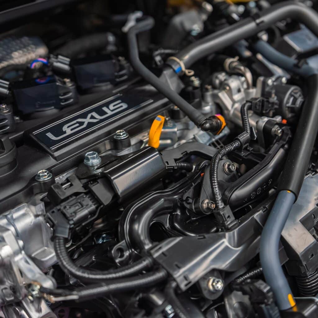 Moteur Lexus : Gros Plan sur la Mécanique de Précision Zoom sur un bloc moteur Lexus avec composants mécaniques détaillés, câblage et logo Lexus argenté visible.